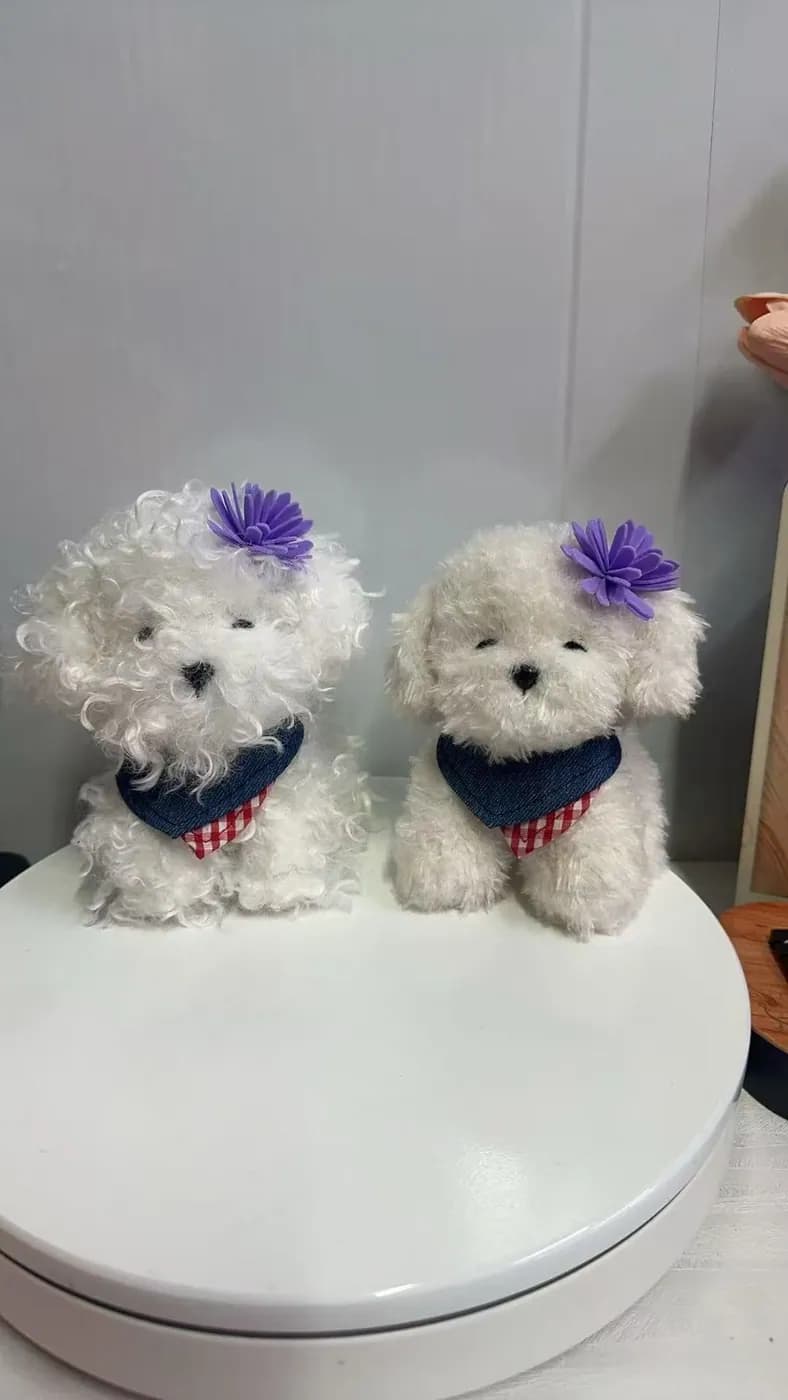 Pair of white poodle plush toys with knitted scarves
