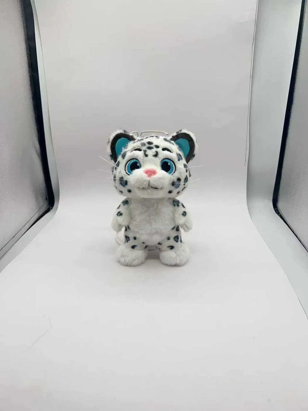 Sitting snow leopard plush toy in short-pile printed fabric