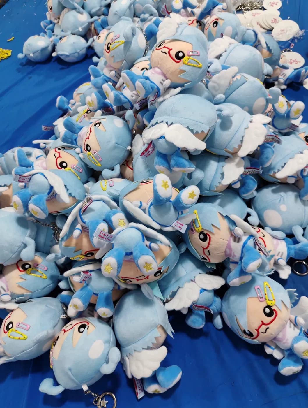 Bulk run of blue plush charms laid out on the packing table