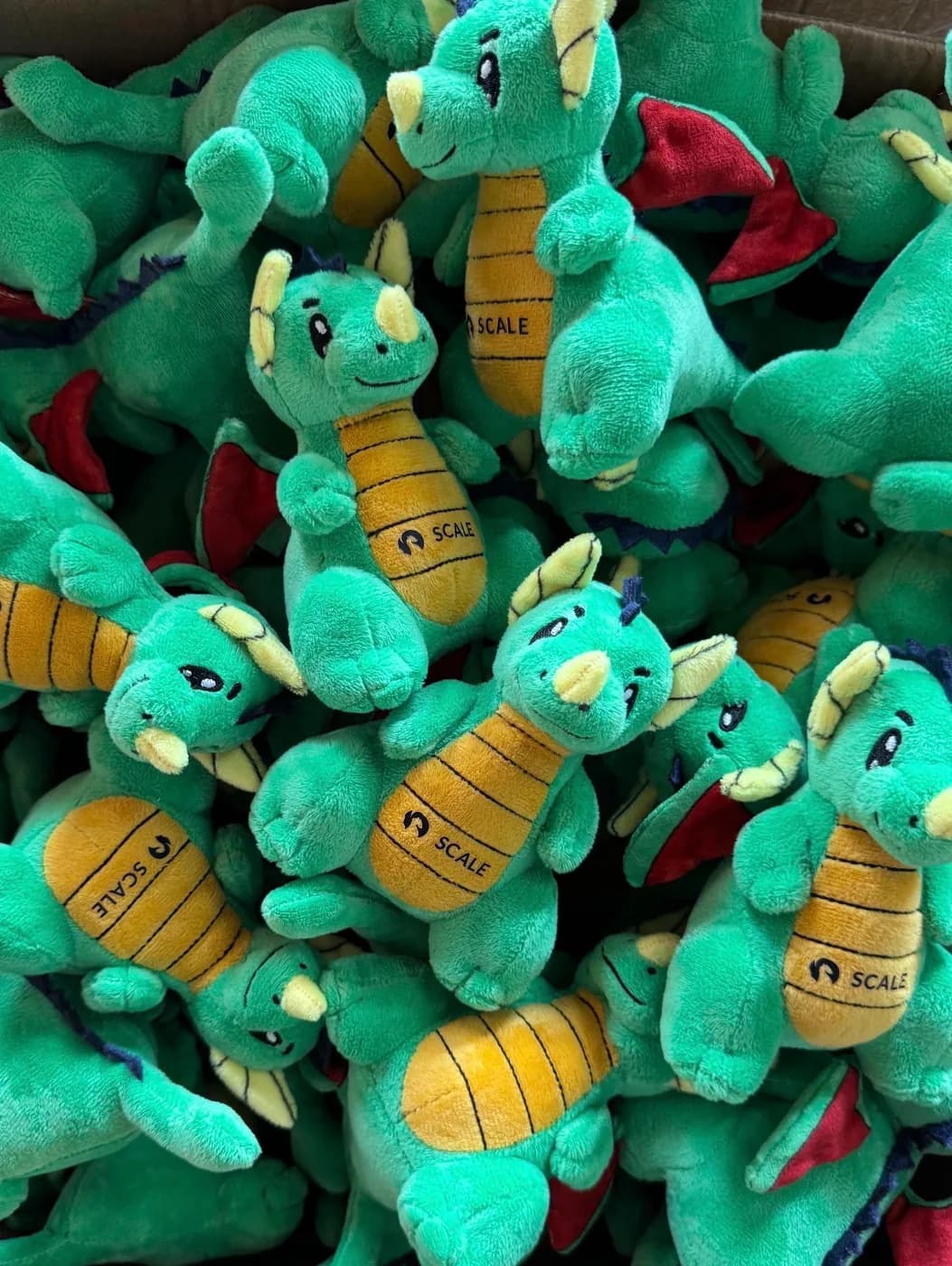 Bulk run of green dragon plush toys ready for packing