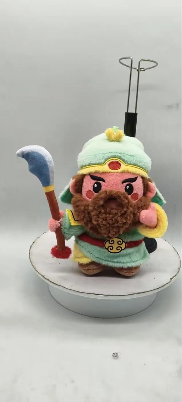 Opera character doll in gold and green robes on a turntable