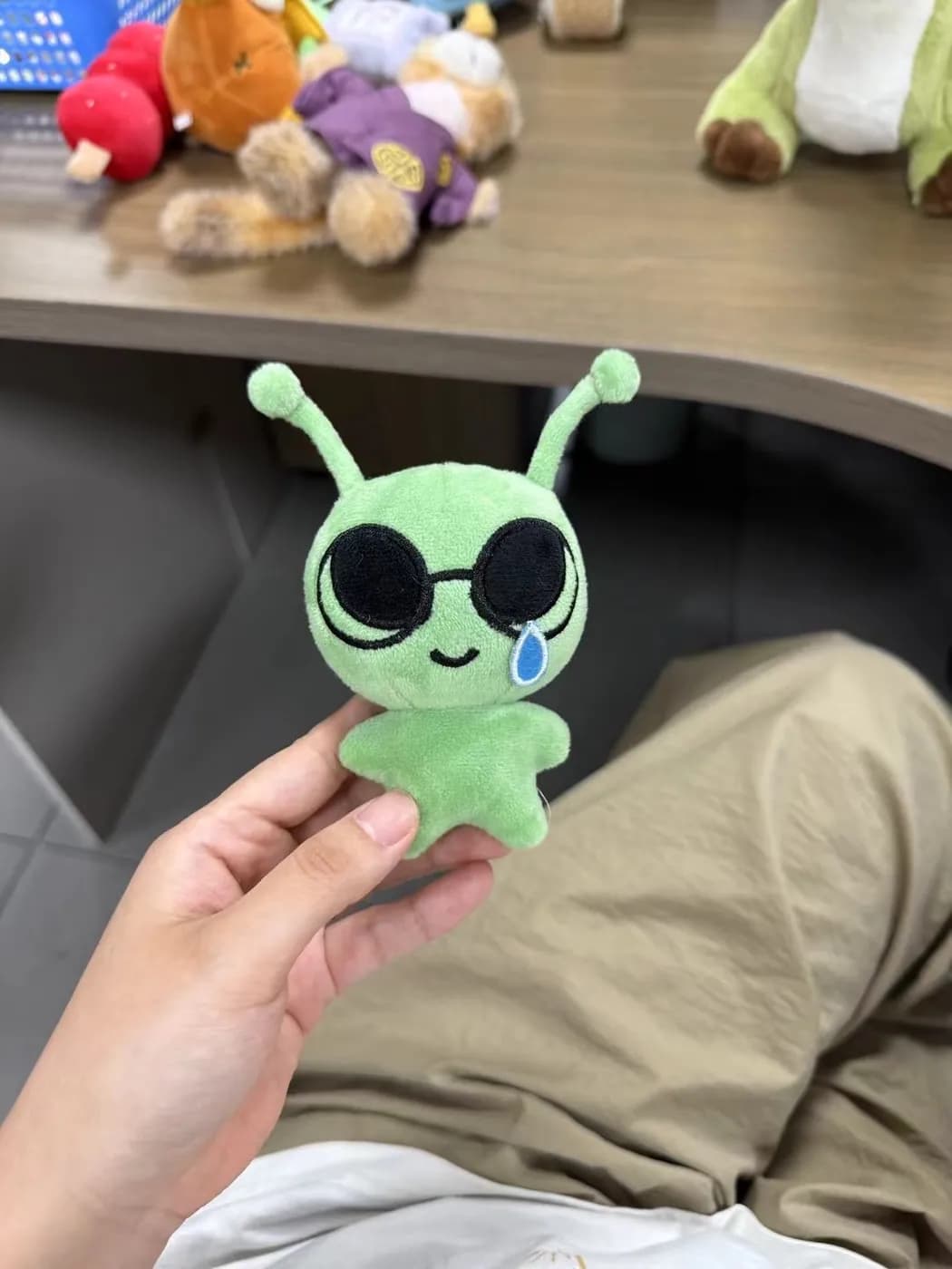 Green alien plush keychain with appliqué eyes and antennae