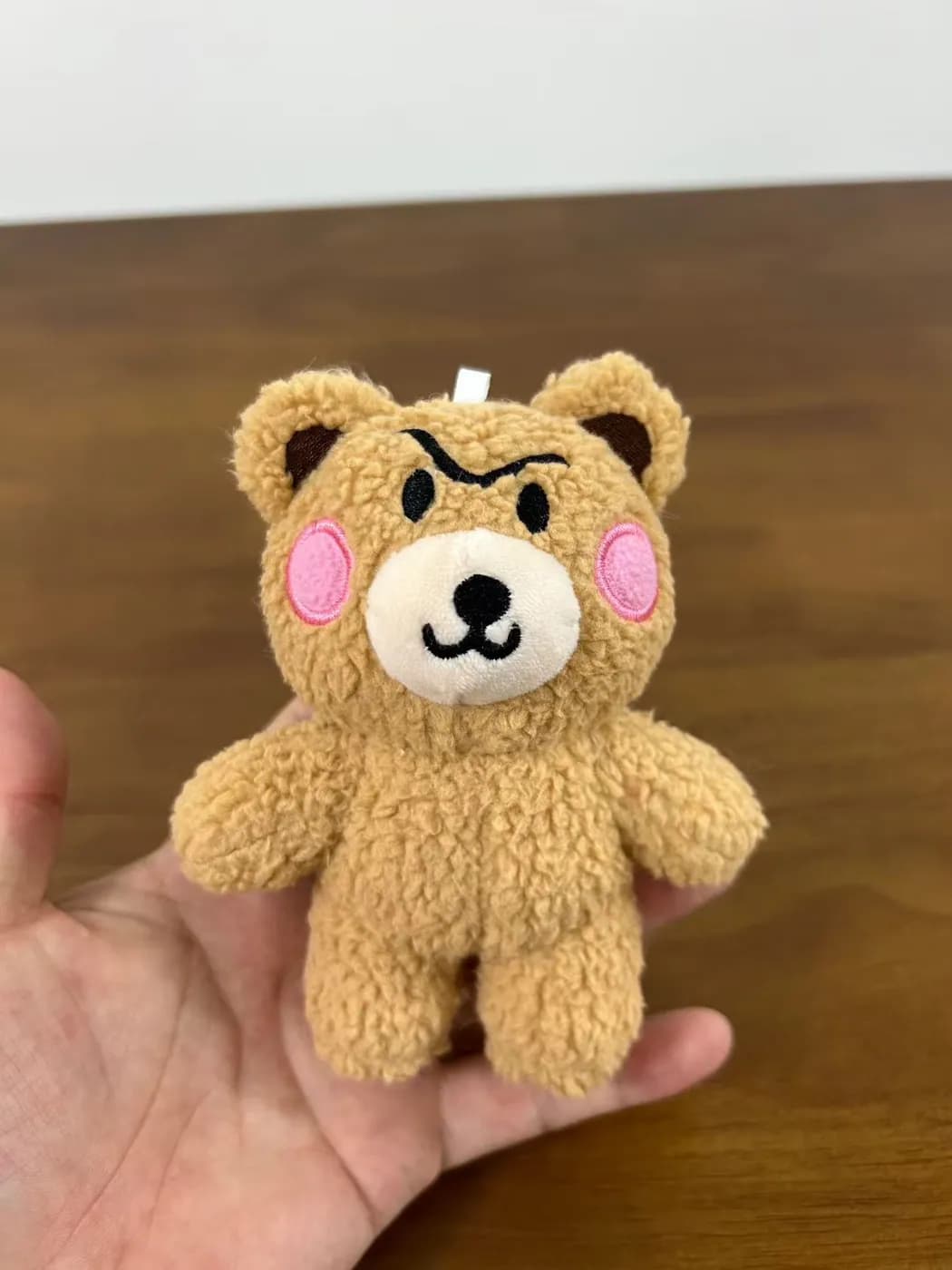Brown bear plush keychain with blushed cheeks and stitched brows