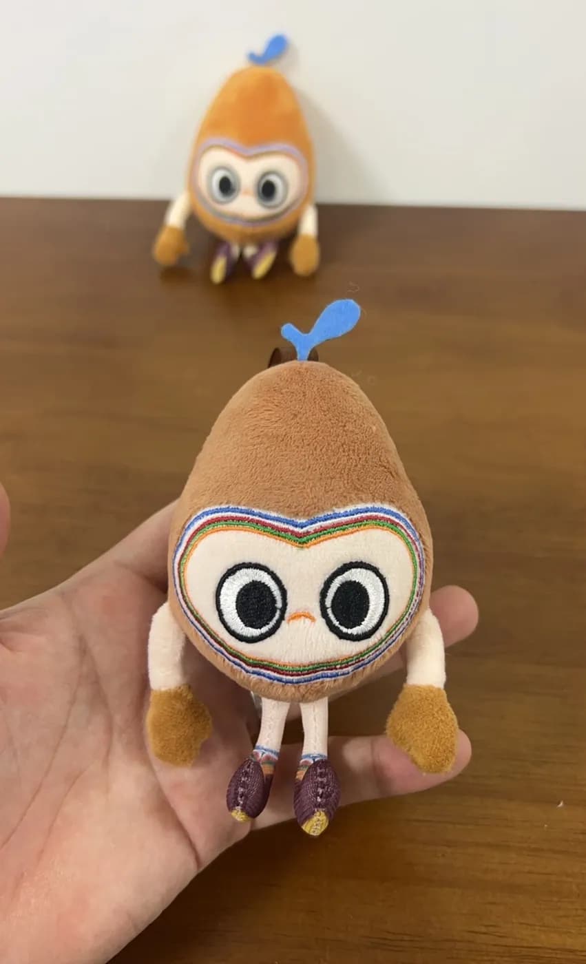 Monkey character plush charms with embroidered bronze mask faces