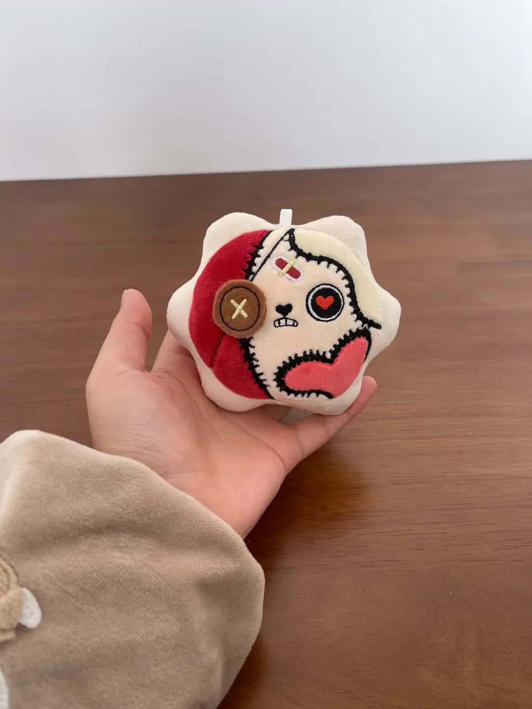 Red opera-face plush charm with contrast appliqué