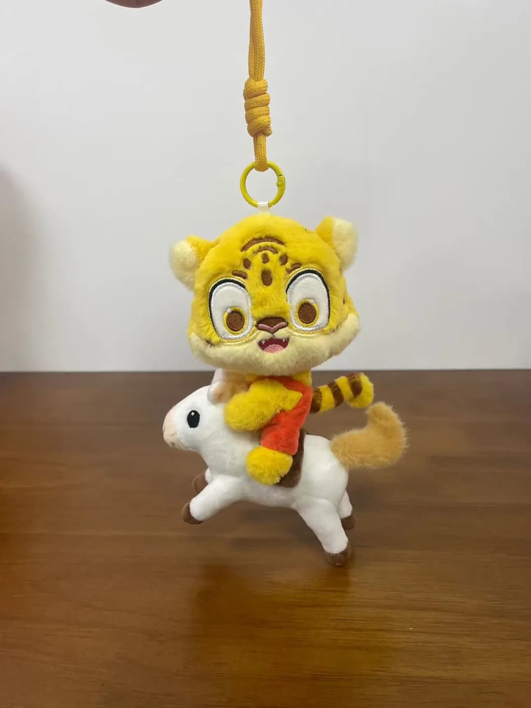 Tiger plush charm on a gold strap with embroidered stripes