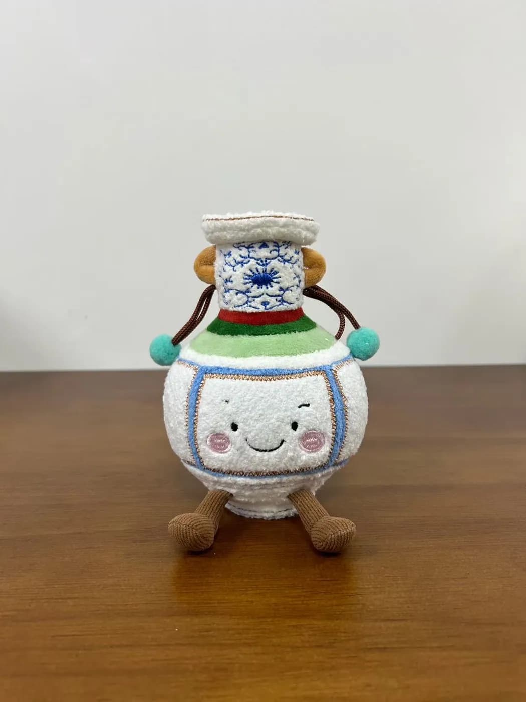 Blue and white porcelain jar plush with a printed pattern and carry cord