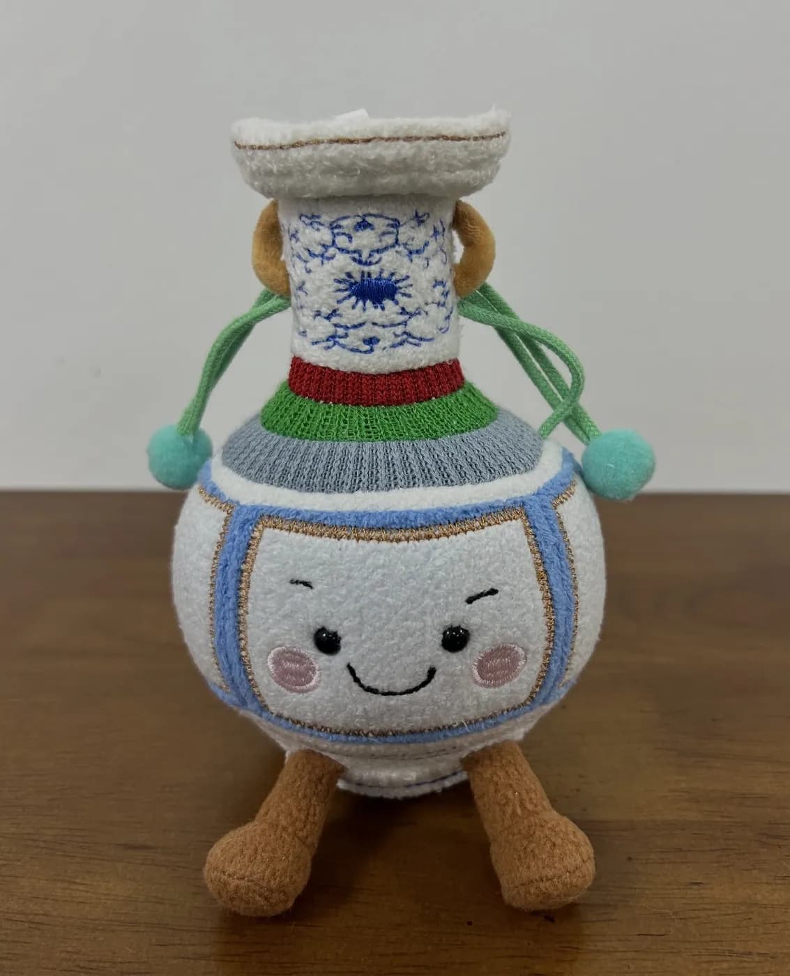 Porcelain vase plush souvenir with a knitted sash and printed motif
