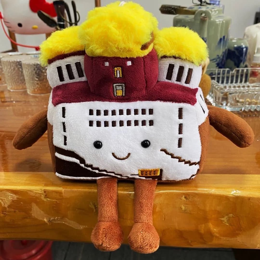 Red castle plush souvenir with a gold roof and appliqué windows