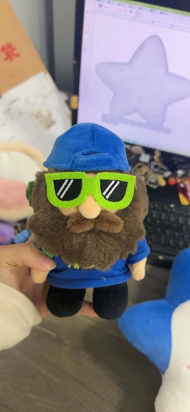 Gnome character mascot plush in appliqué sunglasses and a knitted cap