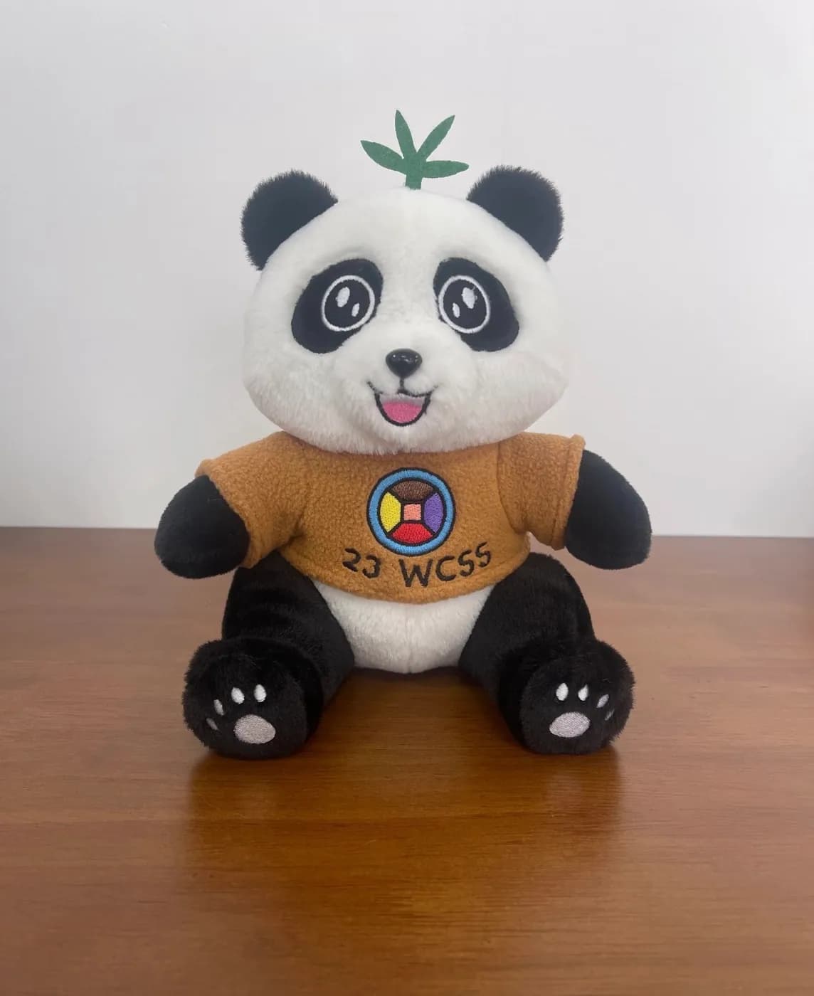 Panda mascot plush in a printed conference T-shirt
