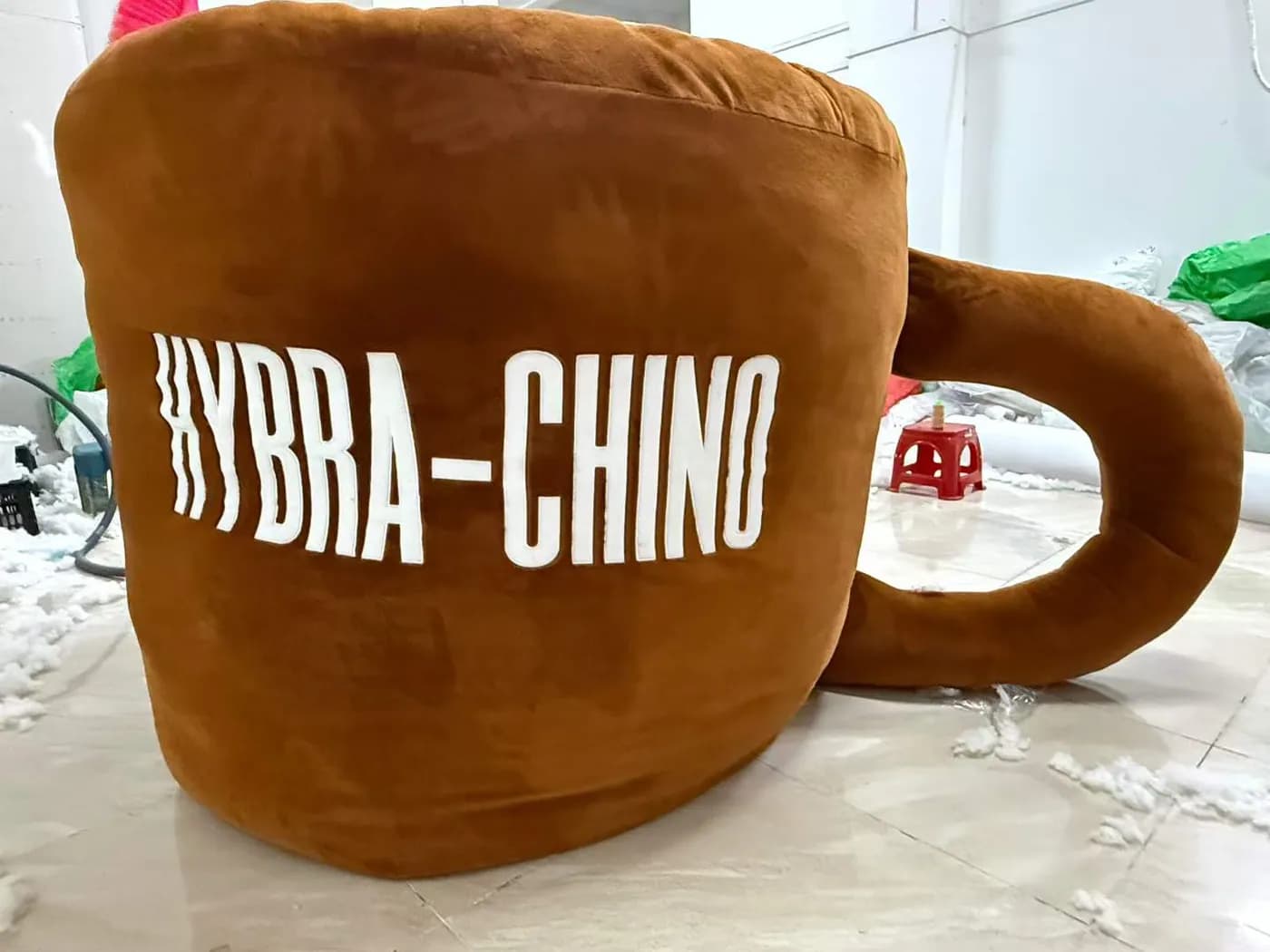 Coffee cup plush cushion with a moulded handle and printed wordmark