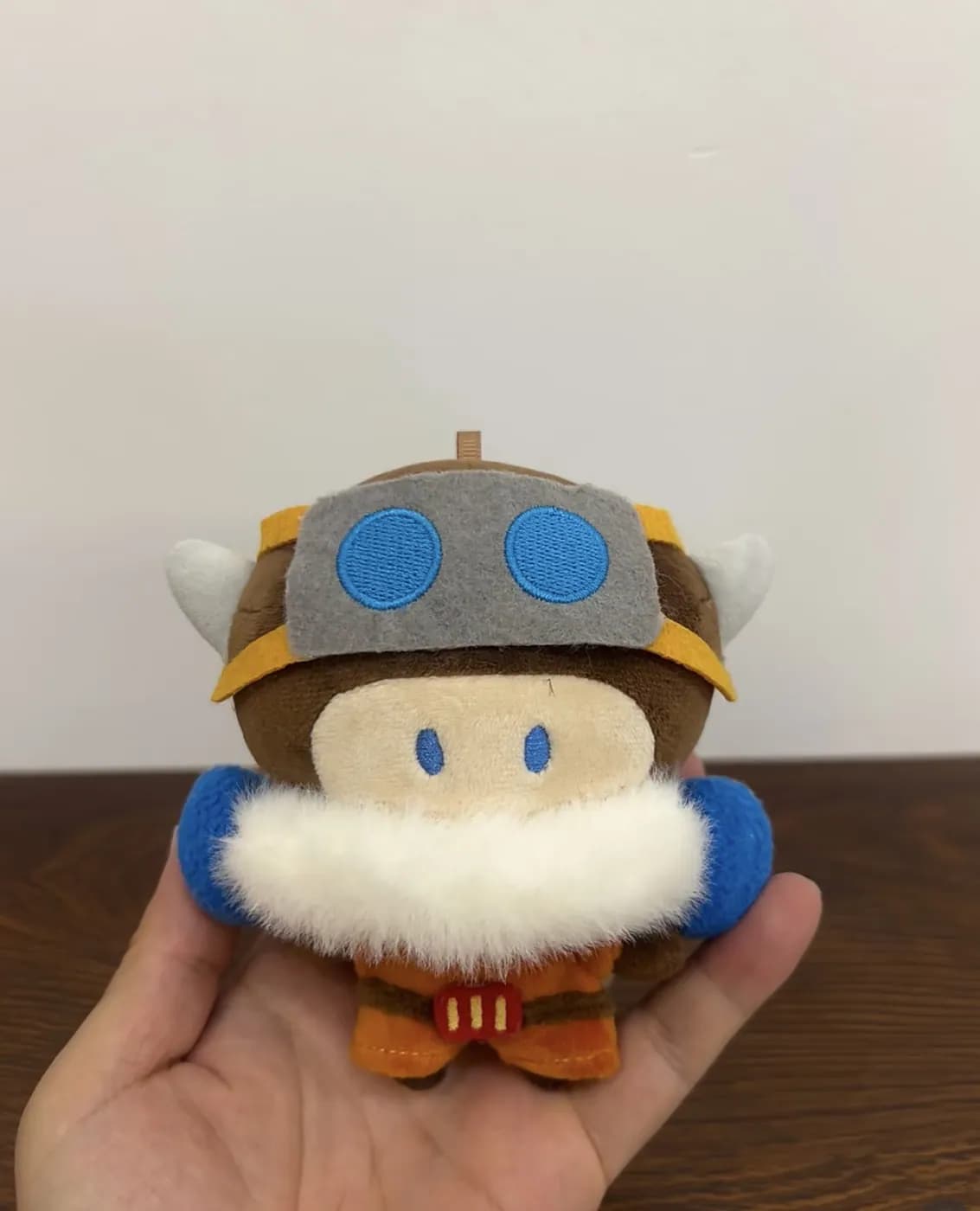 Character plush wearing a moulded helmet and a long-pile fur collar